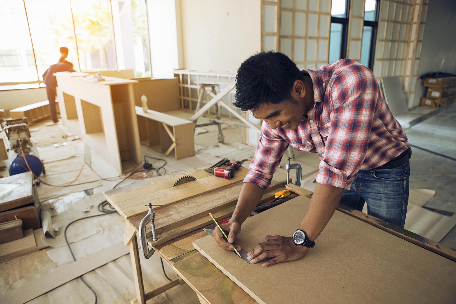 The carpenter is decorating the building site and is happy.